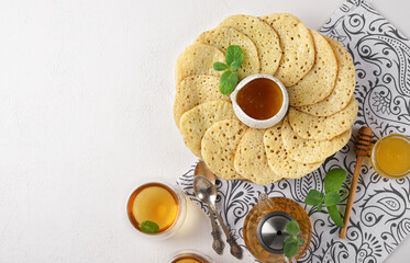Moroccan breakfast with Baghrir, mint tea and honey, copy space