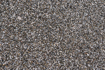 Sea sand closeup flat lay. Sea coarse sand top view flat layout. Gray coarse sea sand on the seashore.