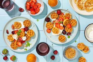 Sweet breakfast with mini waffles and fresh berries, strawberries and cherries. Top view. - obrazy, fototapety, plakaty