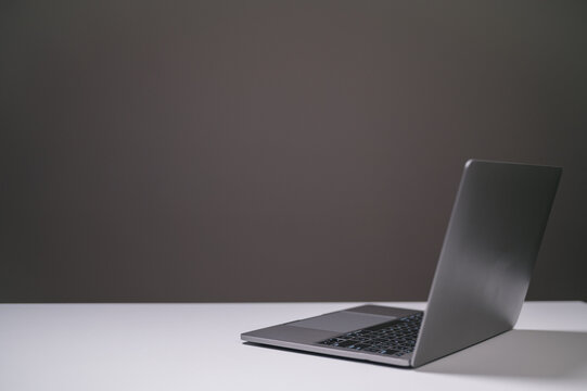 laptop computer on desk in office, black background