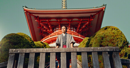 Man, Japanese shinto temple and traditional clothes for culture, building or religion in sunshine. Person, ideas and vision for perspective with faith, mindfulness or thinking with low angle in Kyoto - obrazy, fototapety, plakaty