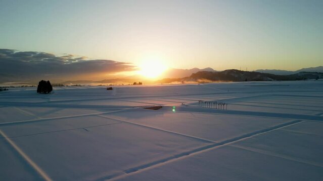 「はさ木」のある雪原を日の出を受けて飛びました（新潟県）