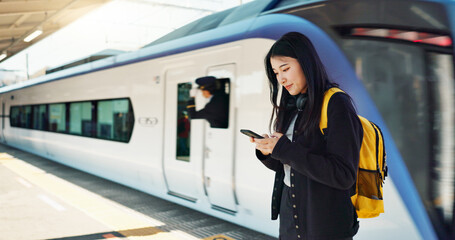 Asian woman, phone and train for travel, communication or social media at railway station. Female...