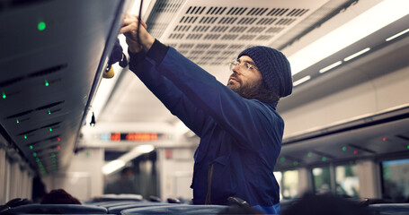 Man, train travel and overhead luggage compartment for storage, safety and property with thinking....