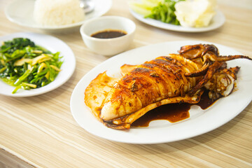 Grilled large squid served with vegetables and fresh chili sauce