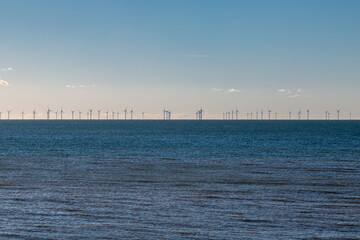 A view of an off shore windfarm on a sunny day