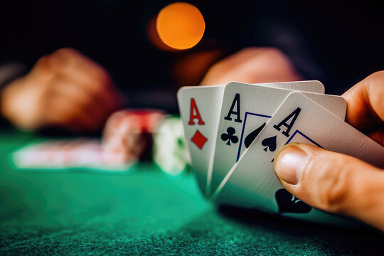 Close-up of a player's hand revealing a pair of aces during a high-stakes poker game in a casino setting.