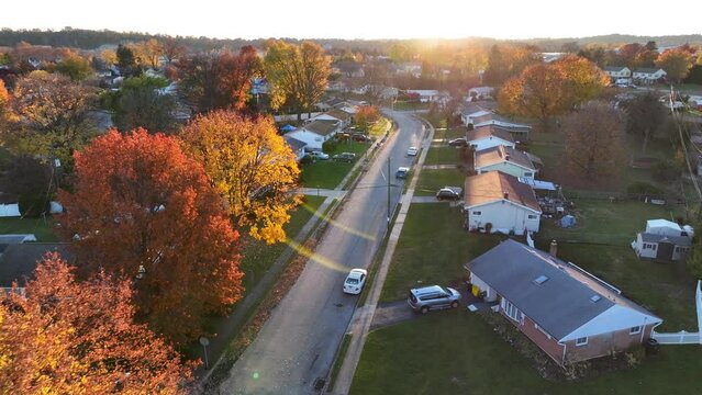 Establishing shot of small town in USA. Colorful autumn fall foliage in neighborhood. Aerial drone shot of homes and houses in United States of America.