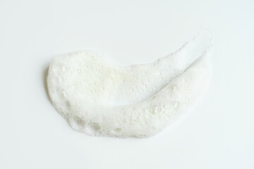 Smear of facial cleansing foam on white background close-up.