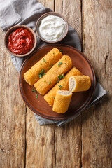 Krokiety Polish style croquettes filled with beef closeup on the plate on the wooden table. Vertical top view from above