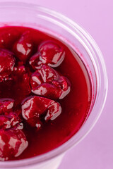 dessert with cream cheese and cherries in a clear glass