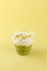dessert with cream cheese and pistachios in a clear glass