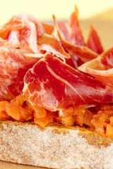 bruschetta with sauce and jamon on a plate.  beige background