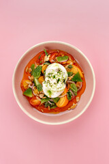 buratta in a bowl with fresh vegetables and sauce