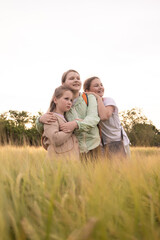 Naklejka na ściany i meble three teenage girls walking in nature, life in the village