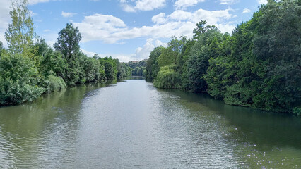 Landscape green with French Clain river in Poitiers France through forest in vienne department