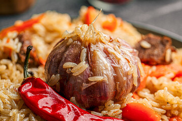 Closeup on cooked garlic bulb in uzbek dish plov