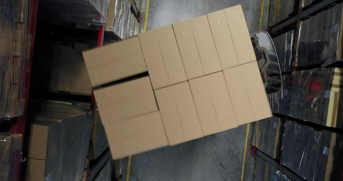 High angle view of forklifts moving boxes in warehouse against white background