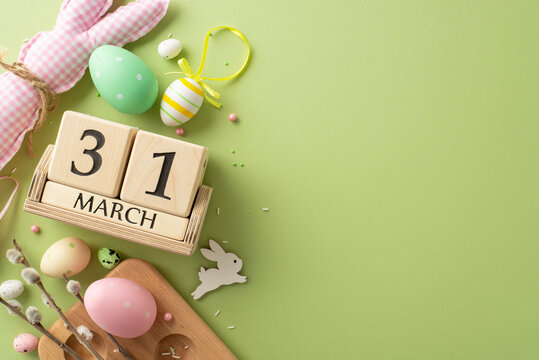 Counting Down to Easter Bliss: Top view of lively eggs in container, charming bunny, date on wooden blocks, pussy willow, sugar sprinkles on pastel green. Advertise your Easter joy here