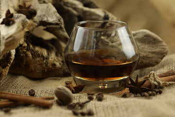 Glass of cognac with spice. Cloth background with copy space
