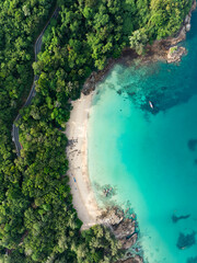 View from above, stunning aerial view of Banana beach, a beautiful white sand beach surrounded by palm trees and bathed by a turquoise water. Phuket, Thailand. - obrazy, fototapety, plakaty