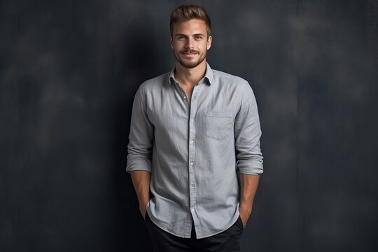 Portrait of a handsome young man standing against a dark background.