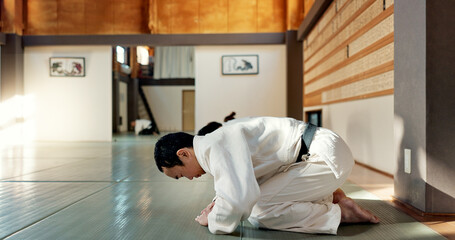 Asian man, class and bow in dojo for respect, greeting or honor to master at indoor gym. Male...