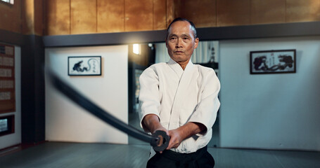 Aikido sword, martial arts and mature man training, self defense or practice combat technique. Dojo...