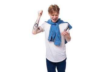 young handsome caucasian man with golden red hair with a tattoo on his arms is dressed in a white t-shirt