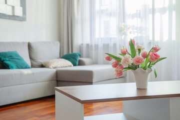 Fototapeta na wymiar pink spring flowers in white ceramic vase in modern home interior