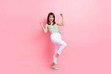 Full length photo of cheerful positive nice girl wear fashionable clothes dance with raised hands isolated on pink color background