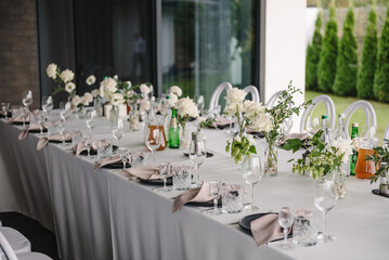Wedding set up, dinner table reception on terrace. Plate and glass, stack, wineglass, luxury rich decor. Serving, setting table in the backyard. Birthday, baptism, event.