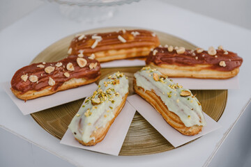 Eclairs. Candy bar on wedding banquet, birthday party, baptism closeup. Pastries with cream on a...