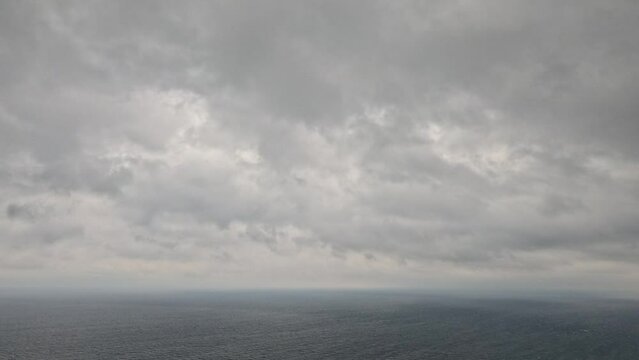 Timelapse rainy Nimbostratus clouds moving in bright sunset sky over stormy sea. Abstract aerial nature summer ocean sunset, sea and sky view. Vacation, travel concept. Weather and Climate Change