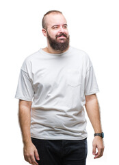 Fototapeta premium Young caucasian hipster man wearing casual t-shirt over isolated background looking away to side with smile on face, natural expression. Laughing confident.