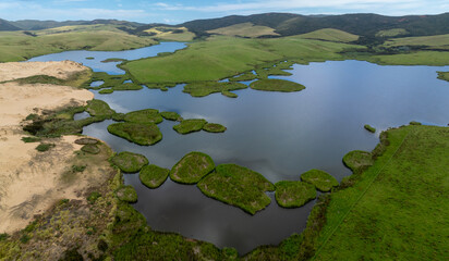 Aerial: Lake, farmland and sand dunes in Cape Reinga, Northland, New Zealand.