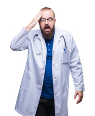 Young caucasian doctor man wearing medical white coat over isolated background surprised with hand...