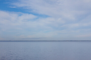 Blue sky with white clouds over the water surface. Nature background. Dnipro river. Ukraine