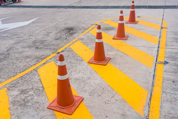 Bright orange traffic cones and yellow lines, do not park.