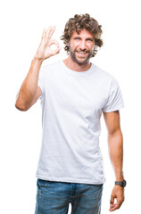 Handsome hispanic model man over isolated background smiling positive doing ok sign with hand and fingers. Successful expression.
