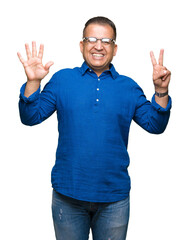 Middle age arab man wearing glasses over isolated background showing and pointing up with fingers number seven while smiling confident and happy.