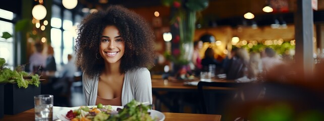 African American woman eating healthy food in a restaurant - Powered by Adobe