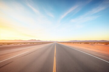 desert highway vanishing into the horizon at sunrise