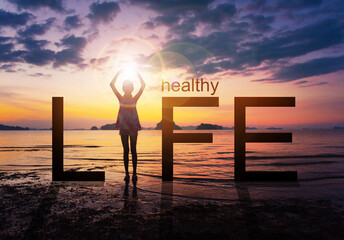 Silhouette of A girl practicing Yoga standing on tropical beach with sunset sky background, watching the sunset, standing as a part of the wording concept for healthy life. 