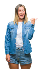 Young beautiful woman over isolated background smiling with happy face looking and pointing to the side with thumb up.