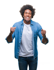 Afro american man over isolated background celebrating mad and crazy for success with arms raised...