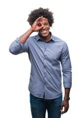 Afro american man over isolated background doing ok gesture with hand smiling, eye looking through fingers with happy face.