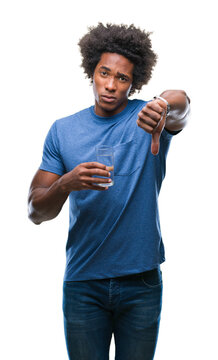 Afro american man drinking glass of water over isolated background with angry face, negative sign showing dislike with thumbs down, rejection concept