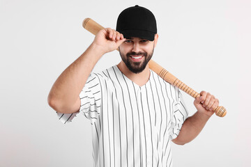Man in stylish black baseball cap holding bat on white background