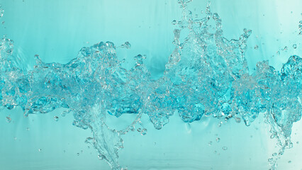 Close-up of splashing water surface on light blue background